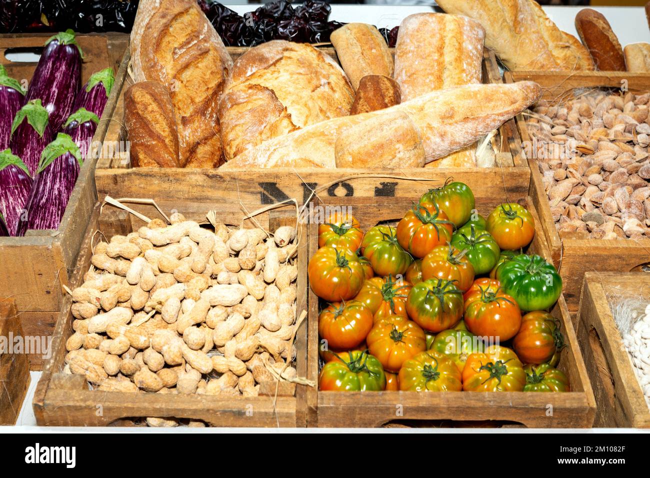 crates at the market with tomatoes, eggplants, peanuts, almonds and bread Stock Photo
