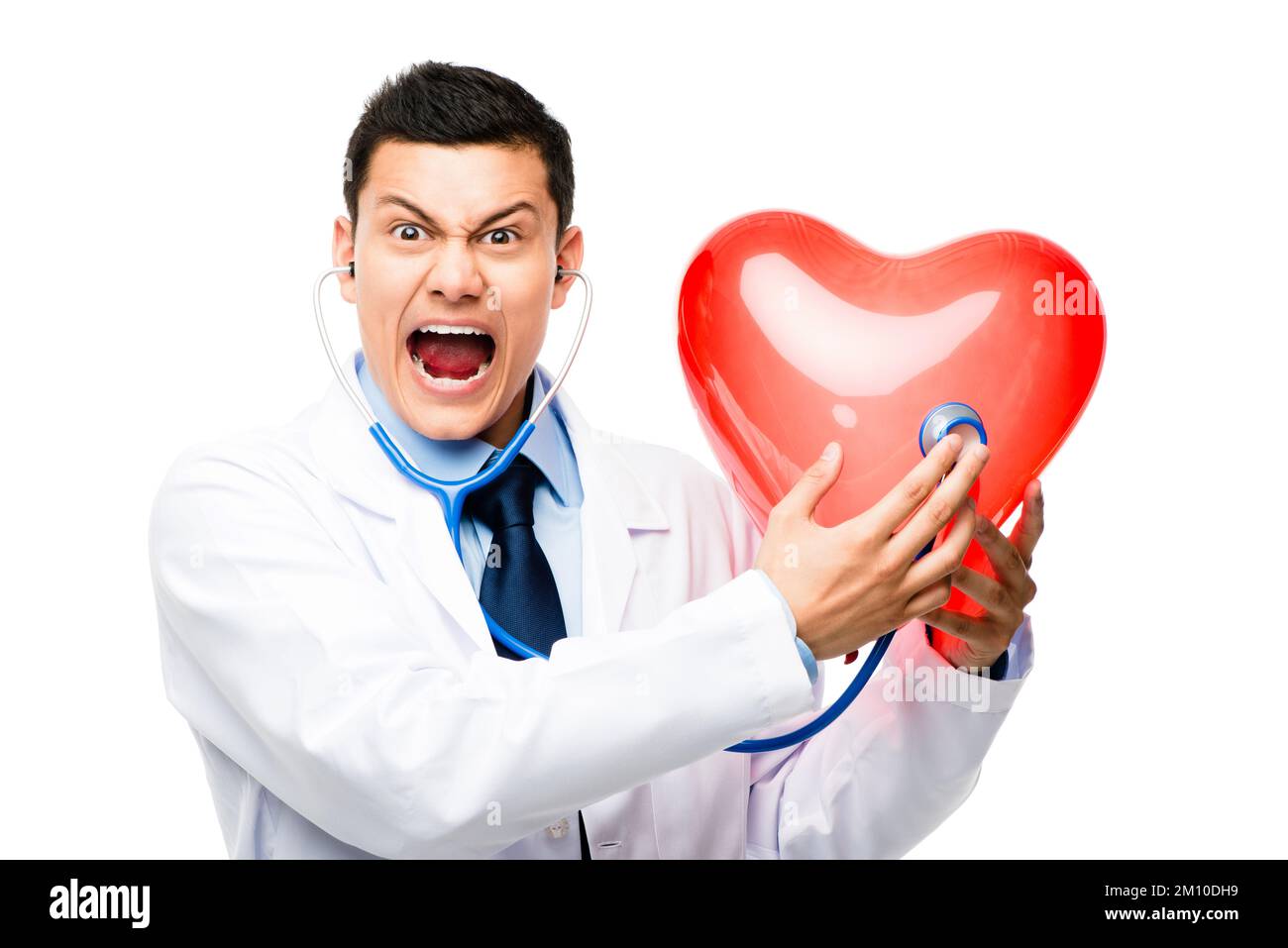 Listening for an irregular heartbeat. a young male doctor holding a heart against a studio background. Stock Photo