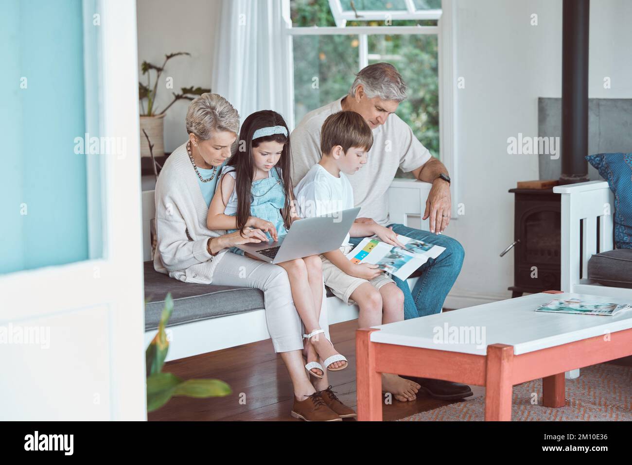 Perfect Sundays spent together. grandparents bonding with their grandkids on the sofa at home. Stock Photo