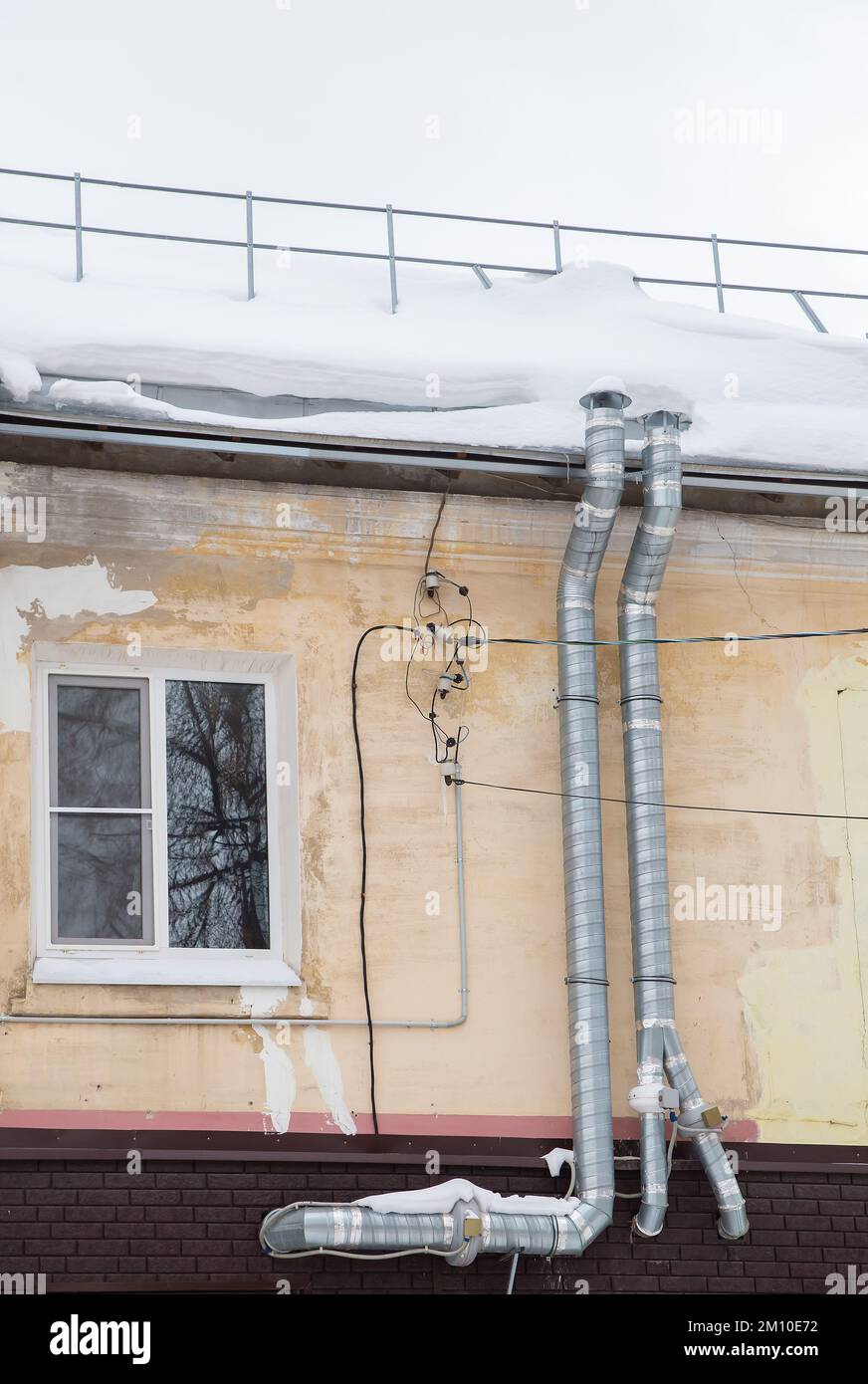 Two long metal exhaust pipes for ventilation on the wall of an old
