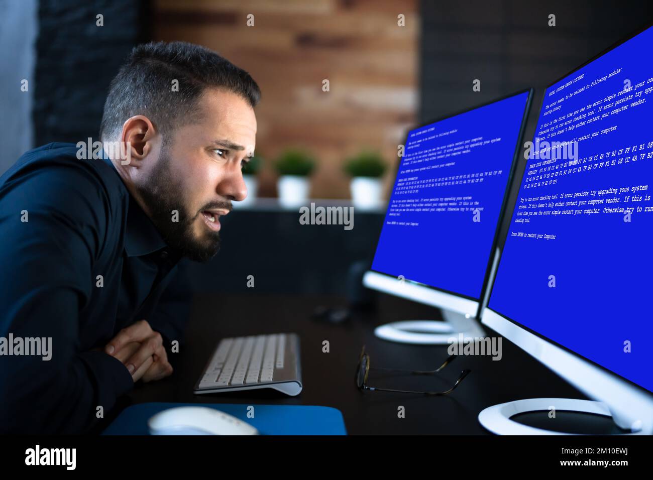 Worried Man At Computer With System Failure Screen At The Workplace Stock Photo