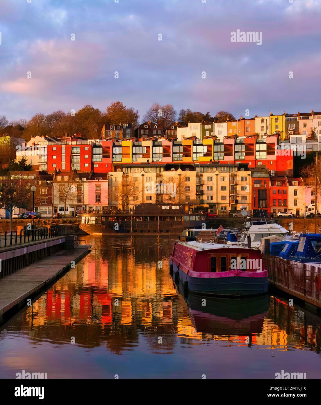 The iconic houses projecting a punch of colour when reflected in Bristol Marina slipway from a golden winter sunset. Stock Photo