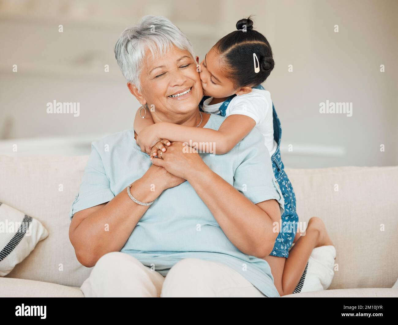Blended families woven together by choice. a grandmother and granddaughter bonding on the sofa at home. Stock Photo