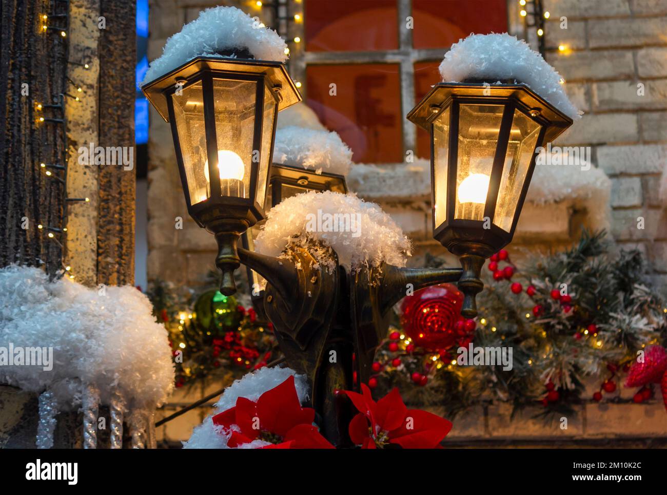 Vintage Christmas lanterns burning with a candle hanging on a house on a  blurred background Stock Photo - Alamy