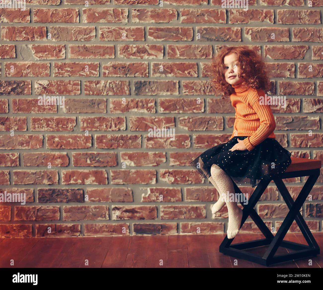 cute little girl sitting on a chair in a new living room Stock Photo ...