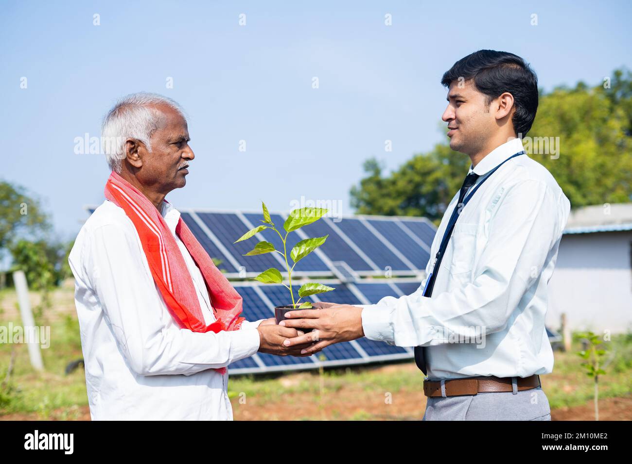 Save Engineer Engineer giving plant to farmer in front of solar power plant at ...