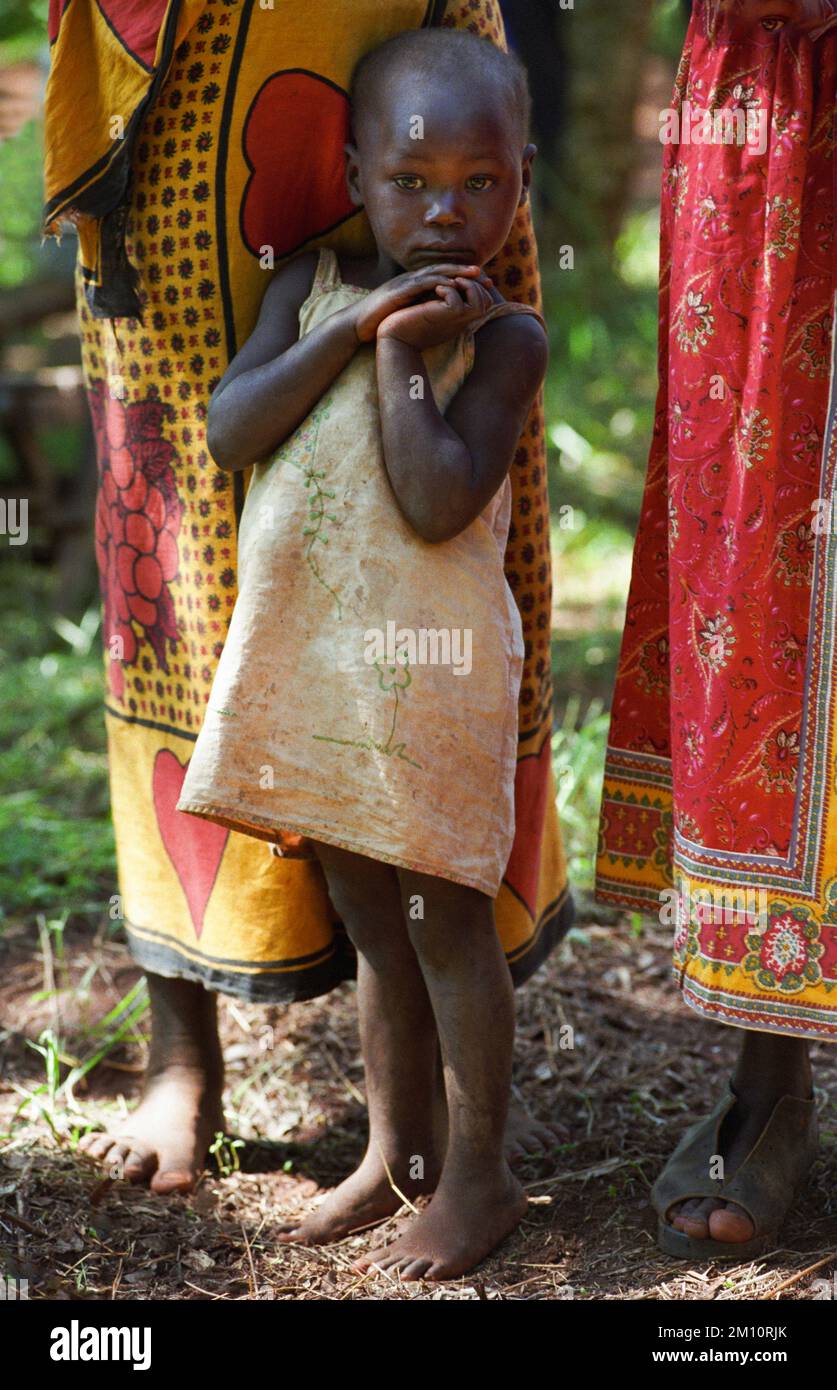 Child Standing Between Women, Kenya Stock Photo