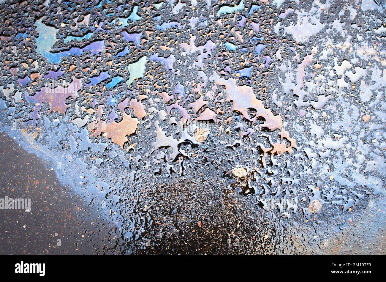 Oil stains from leaks in the car engine. Oil after rain makes spots