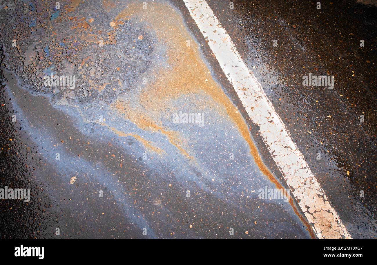 Oil spill on dark asphalt, parking lot with dividing lines Stock Photo