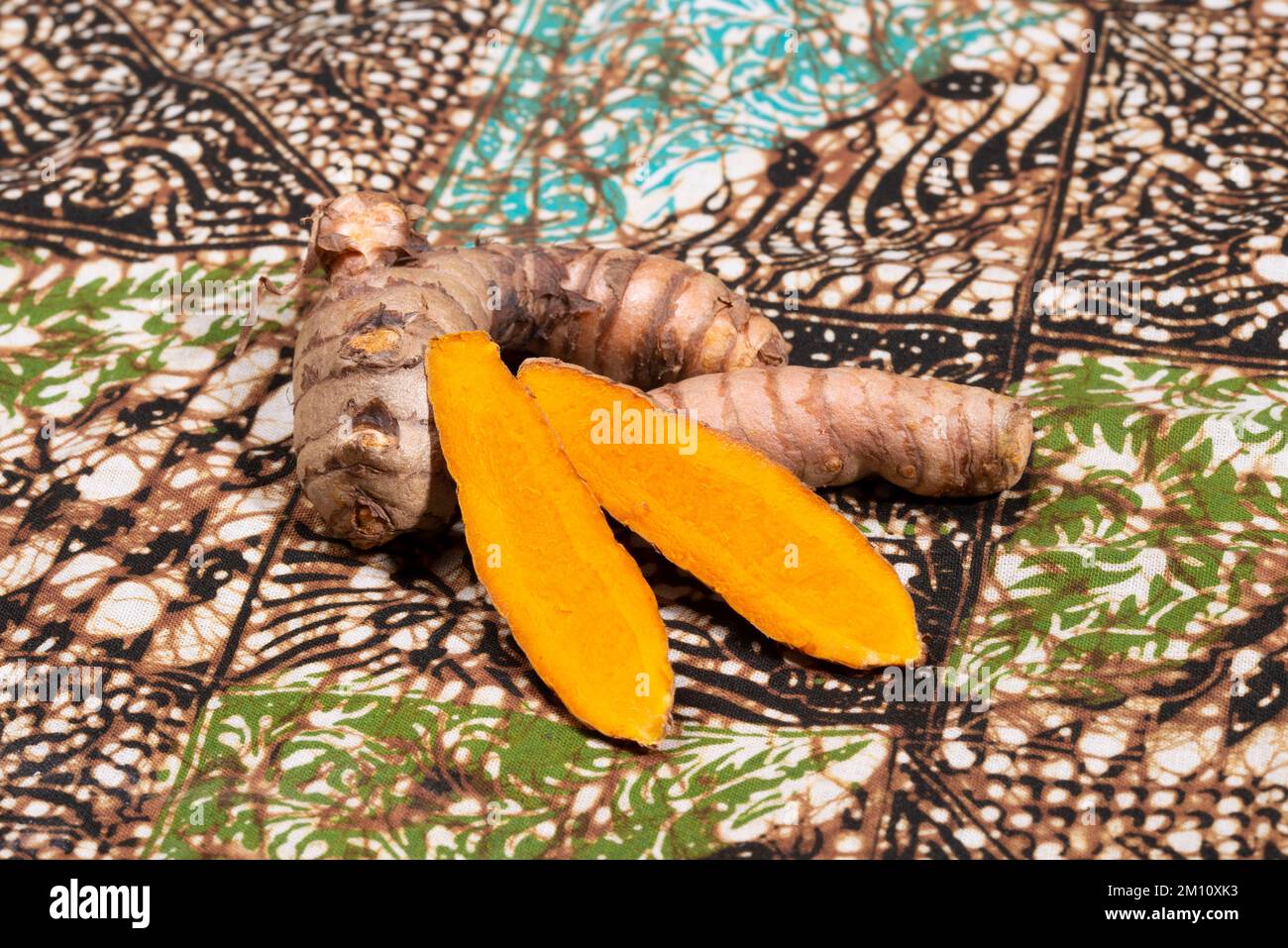 Fresh turmeric on a Indonesian batik table cloth. Stock Photo