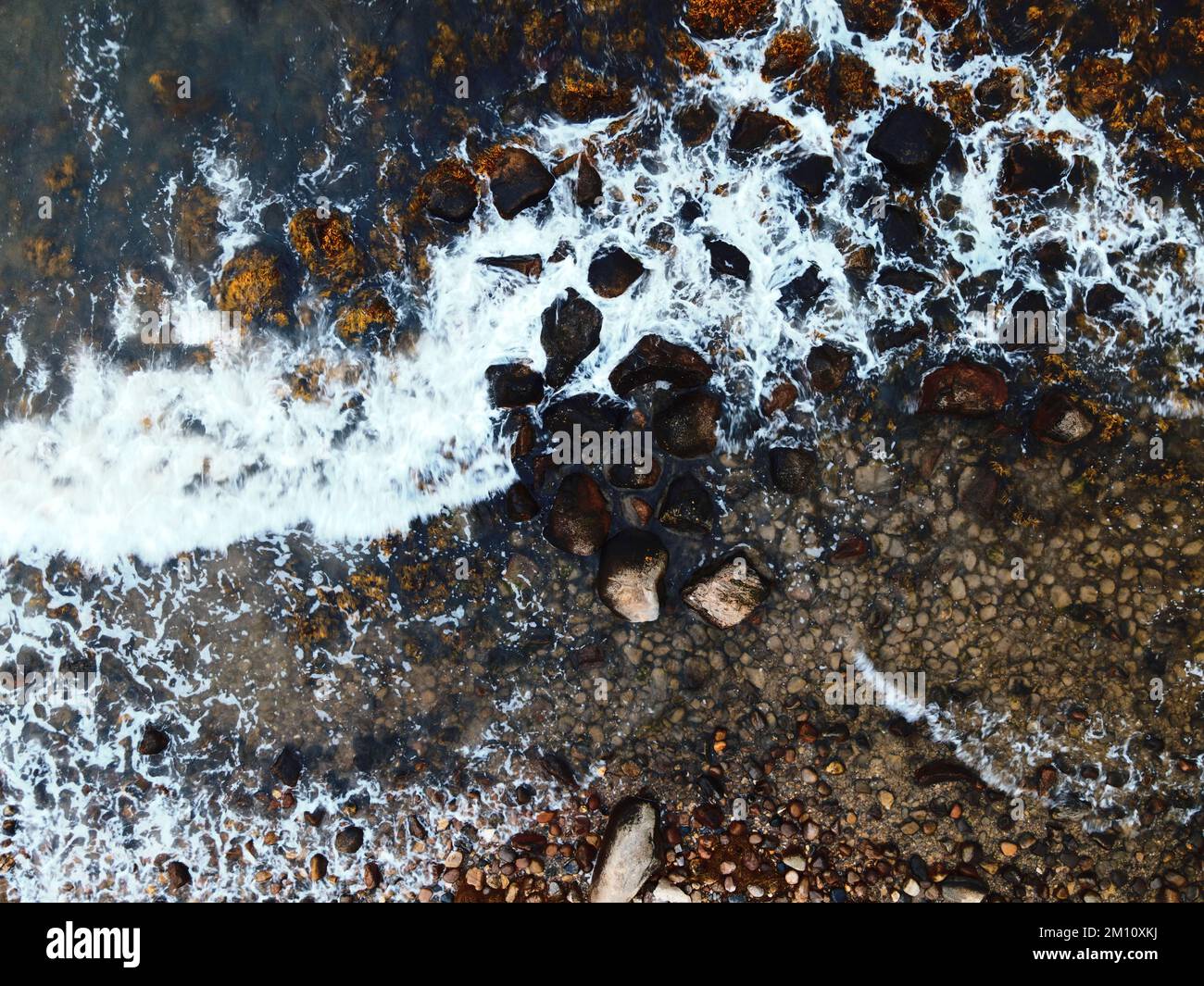 A top view of the waves hitting the rocky shore Stock Photo - Alamy