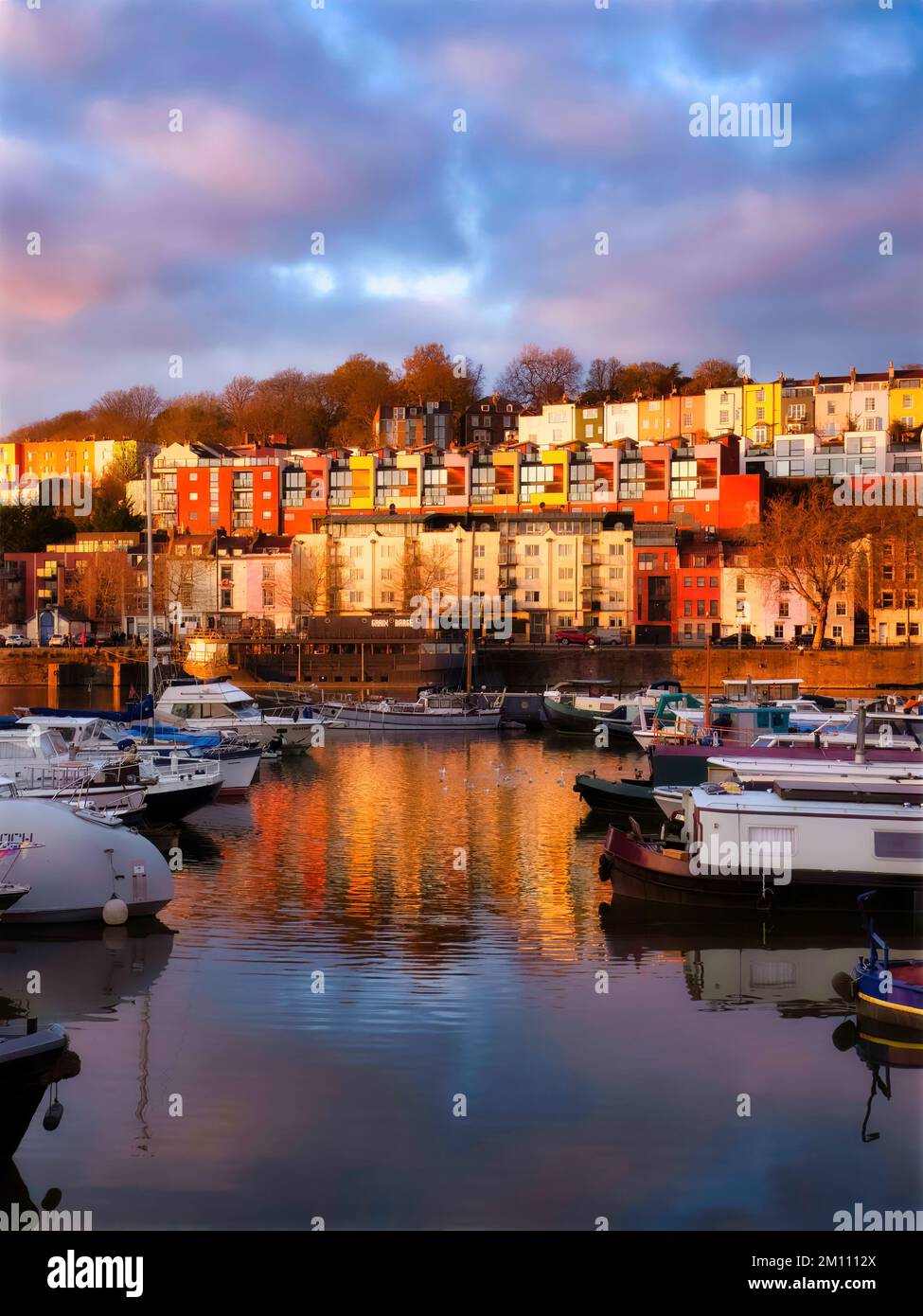 The warm golden light of a winter sunset illuminating the houses facing Bristol marina and truly enhancing their wonderful colours. Stock Photo