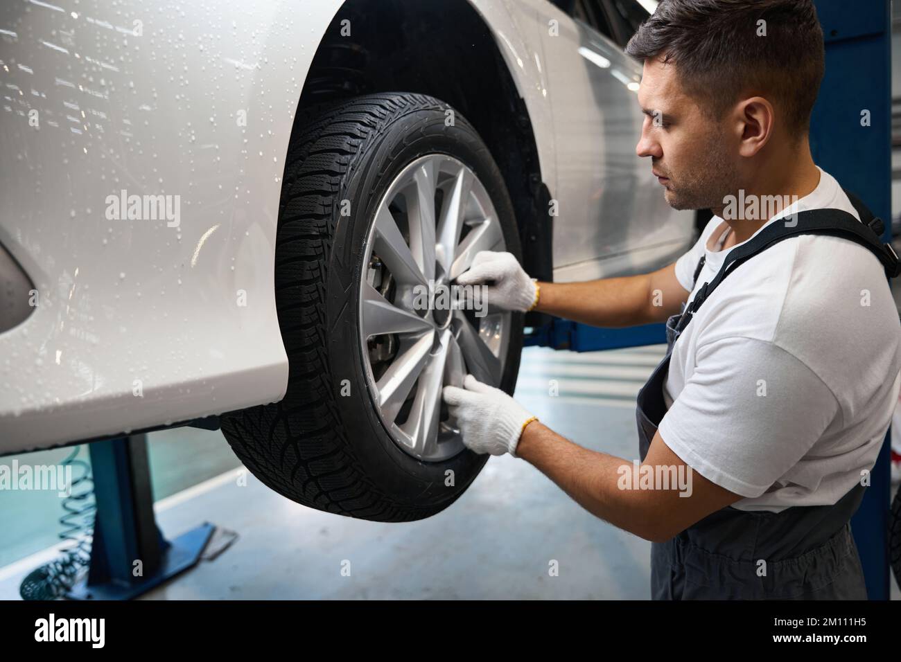 Mechanic changing car wheel in tire fitting Stock Photo