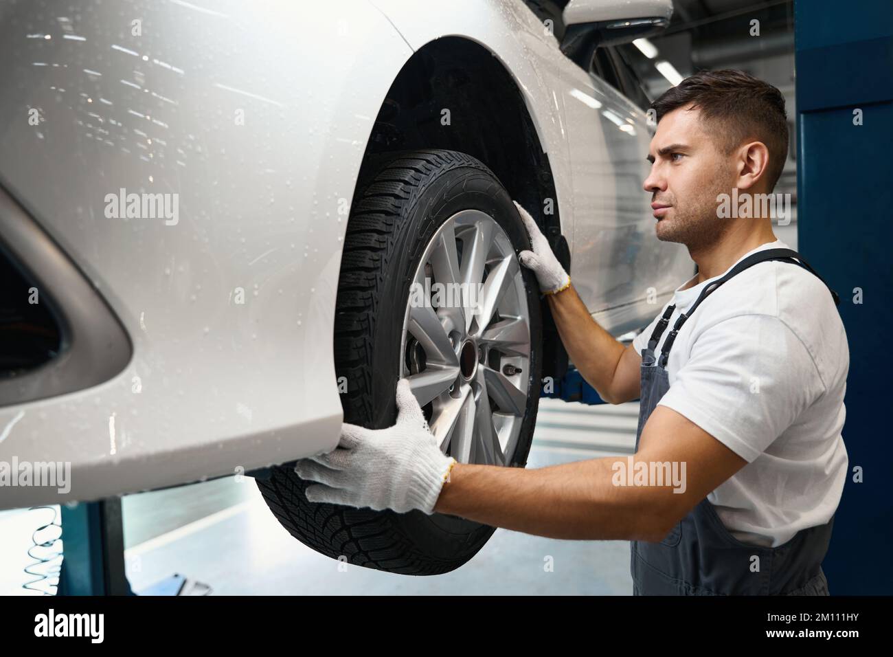 Worker changing car wheel in tire fitting Stock Photo