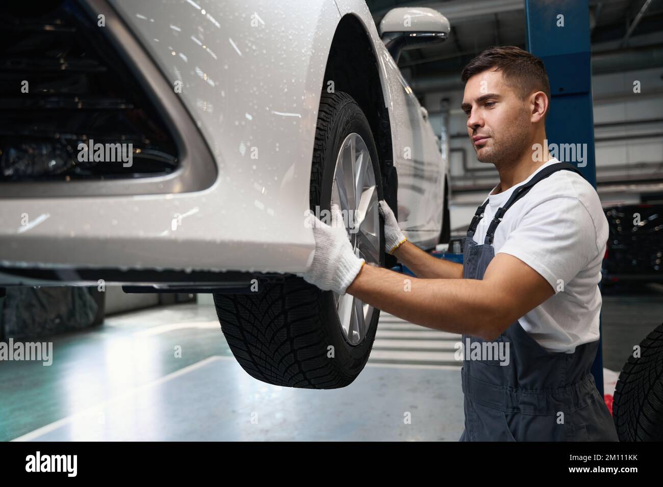 Professional mechanic changing car wheel in tire fitting Stock Photo
