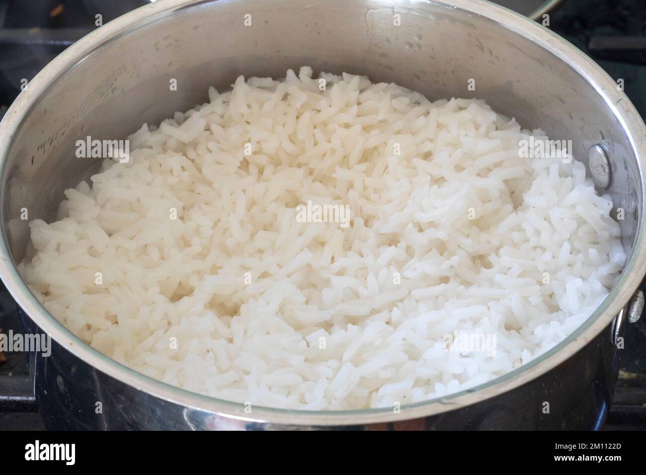 Cooking steamed rice in a saucepan Stock Photo