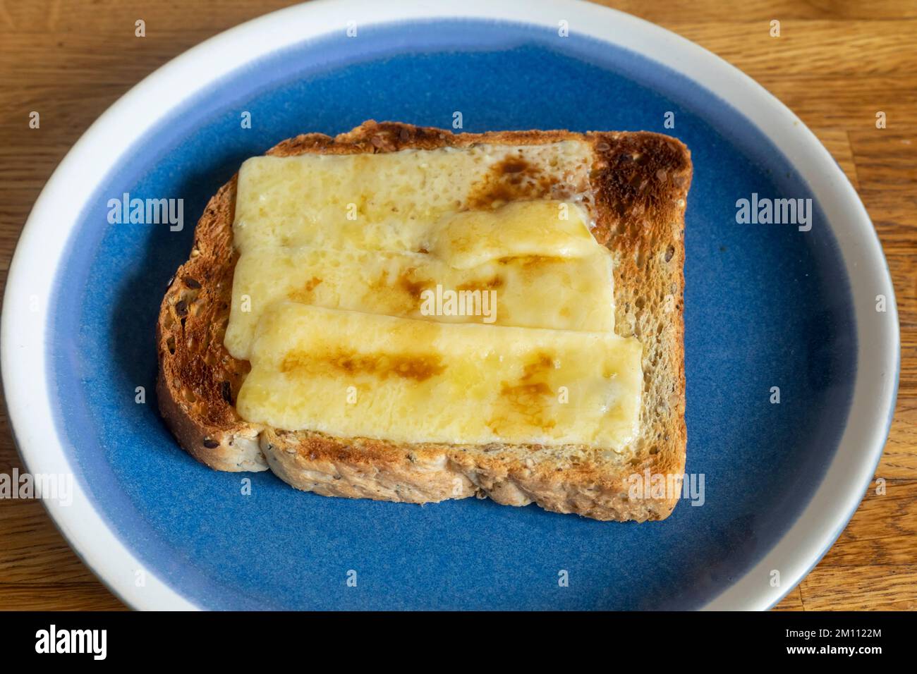 Cheese on toast with Worcestershire sauce on a blue plate Stock Photo
