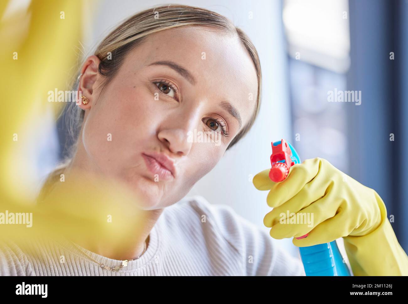 Cleaner woman, spray and bottle in portrait while working with product, detergent or sanitizer in home. Hygiene worker, cleaning and spray bottle for Stock Photo