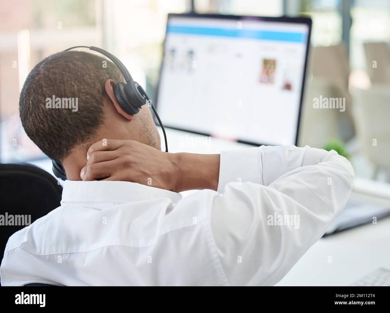 Call center, advice and neck pain with a man feeling body ache while in a telemarketing and communication job. Burnout, stress and physical strain in Stock Photo