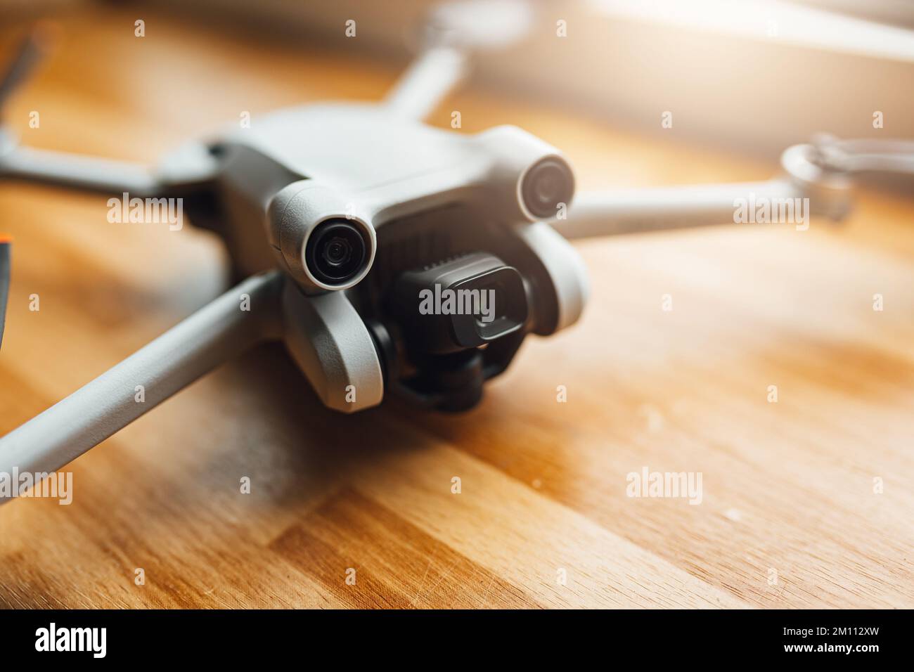 A small size drone placed on a wooden background in front of the window Stock Photo