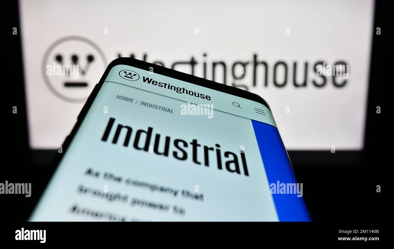 Smartphone with webpage of US company Westinghouse Electric Corporation on screen in front of business logo. Focus on top-left of phone display. Stock Photo