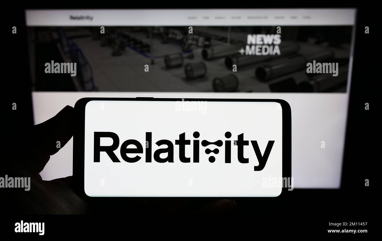 Person holding smartphone with logo of US aerospace company Relativity Space Inc. on screen in front of website. Focus on phone display. Stock Photo