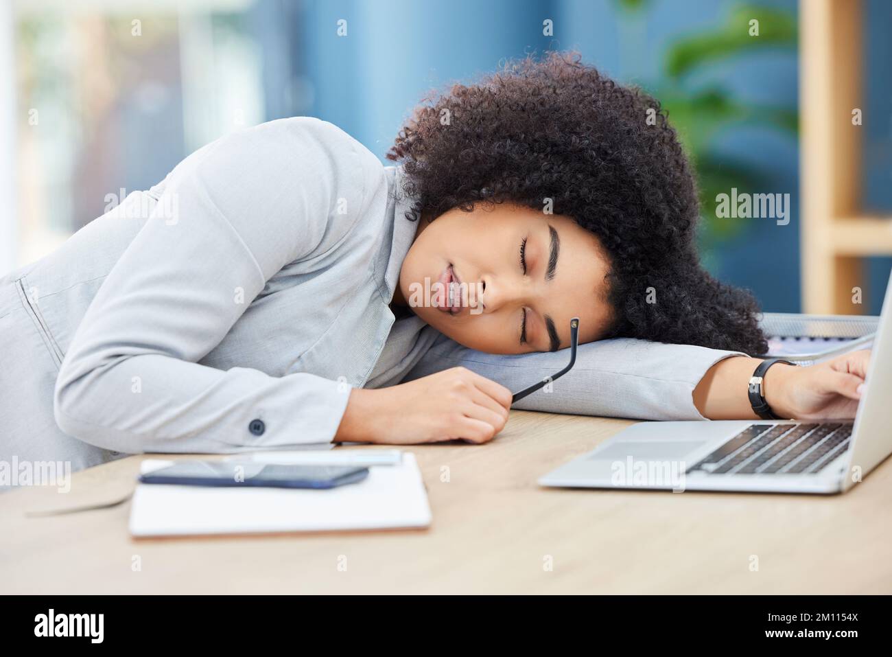 Black woman, sleeping and office desk while tired, burnout and fatigue while asleep by laptop at corporate company, head on table to relax. Lazy Stock Photo
