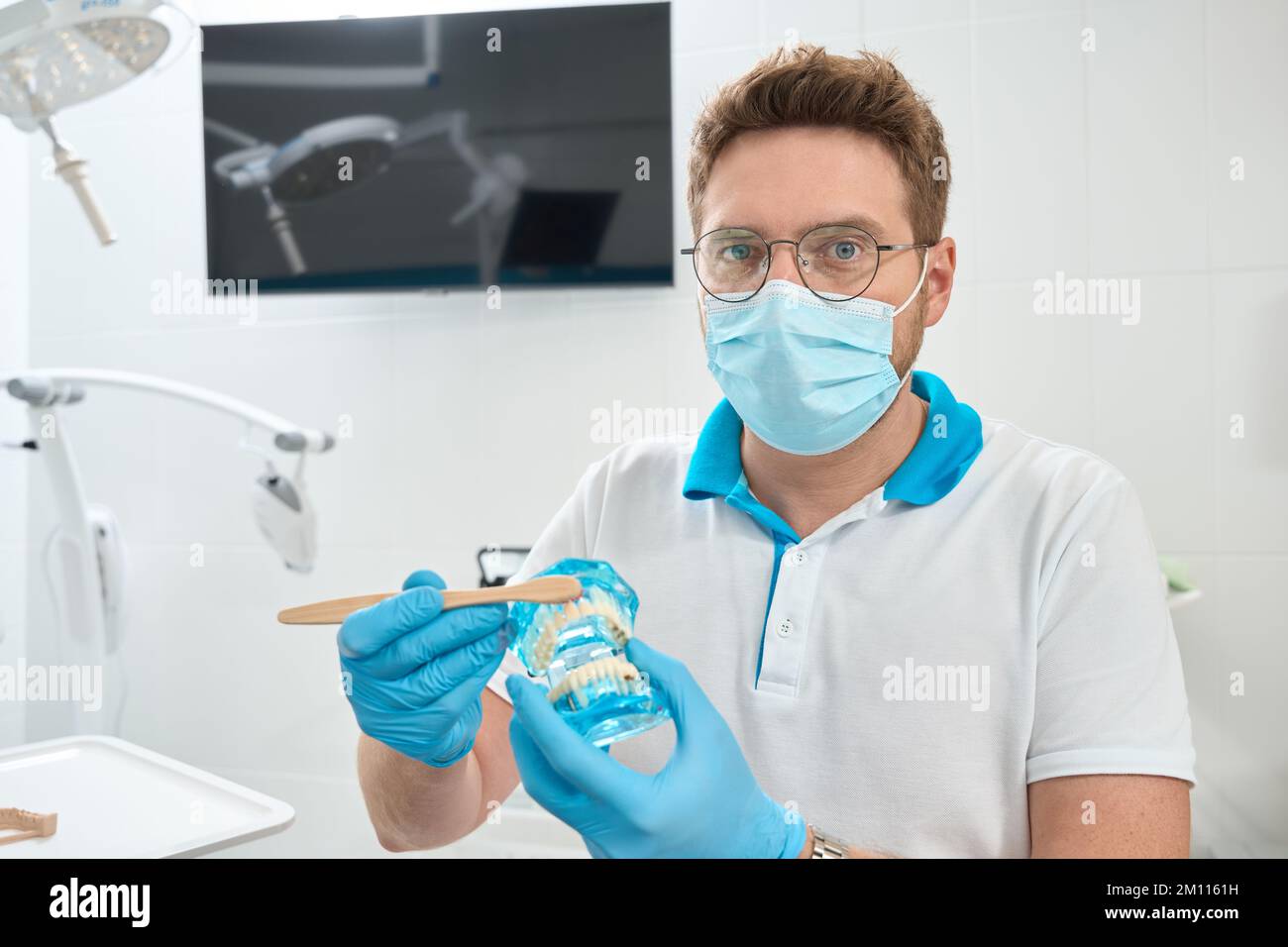 Professional dentist demonstrating toothbrushing technique before