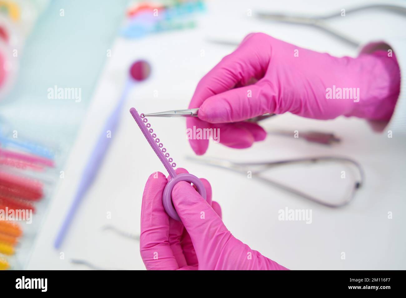 Doctor dentist tears off polishing disc from common palette with tweezers Stock Photo