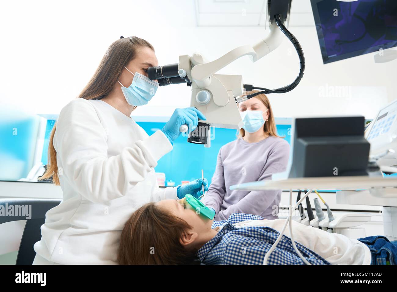 Root canal treatment for a boy in dental clinic under microscope Stock