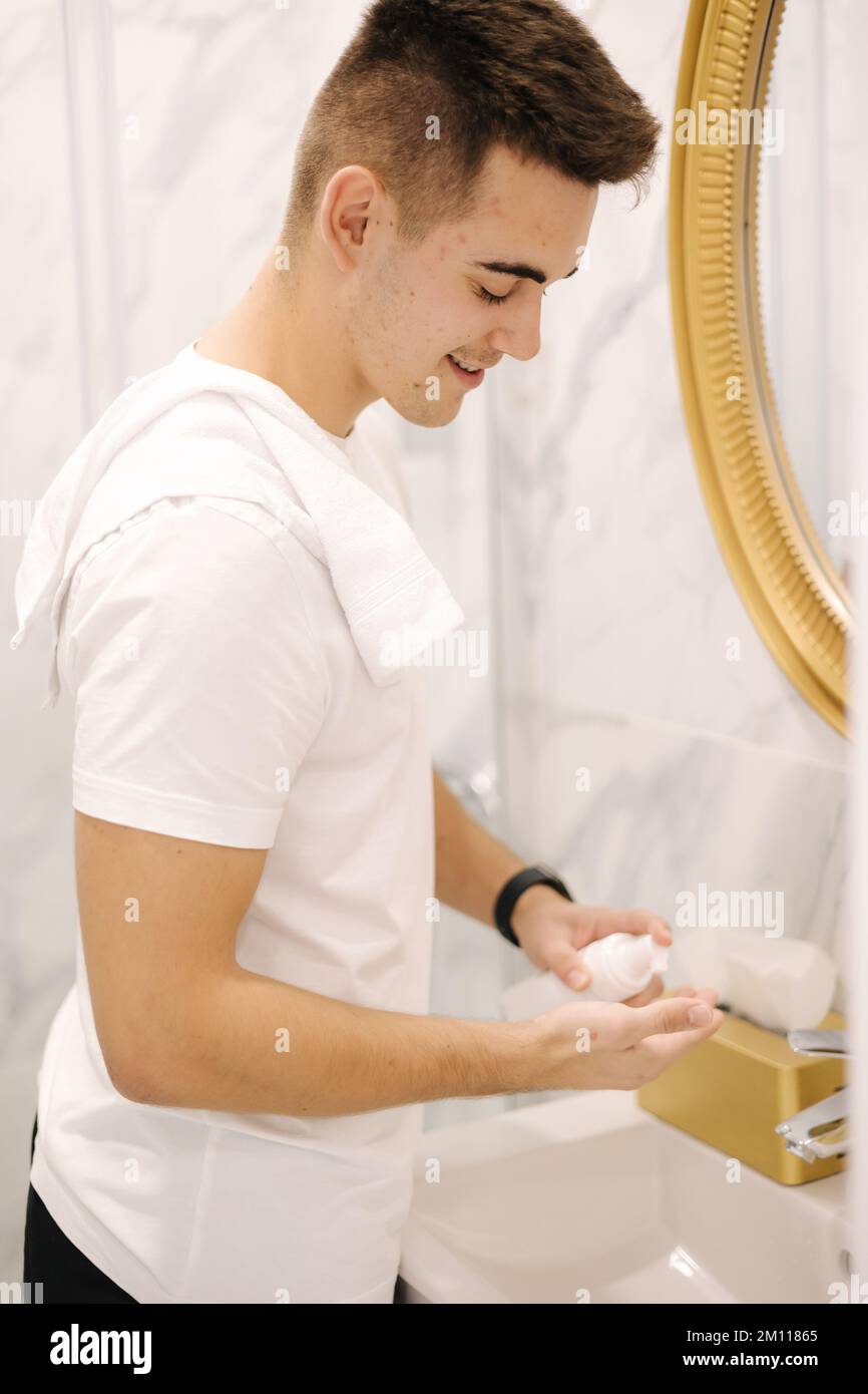 Man using cream for hands and face at home in the bathroom. Keep clean concept Stock Photo