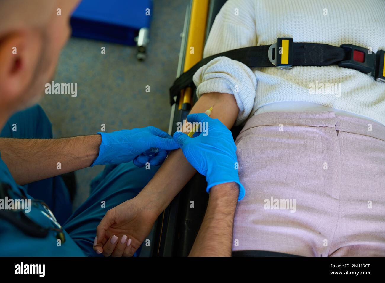 Medical worker injects medicine into vein in a female arm Stock Photo