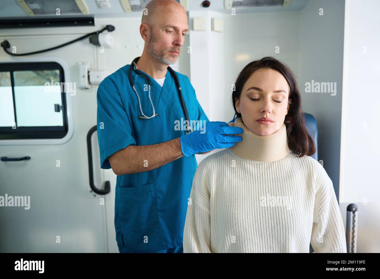 Medical worker checks the fastening of brace on the neck Stock Photo
