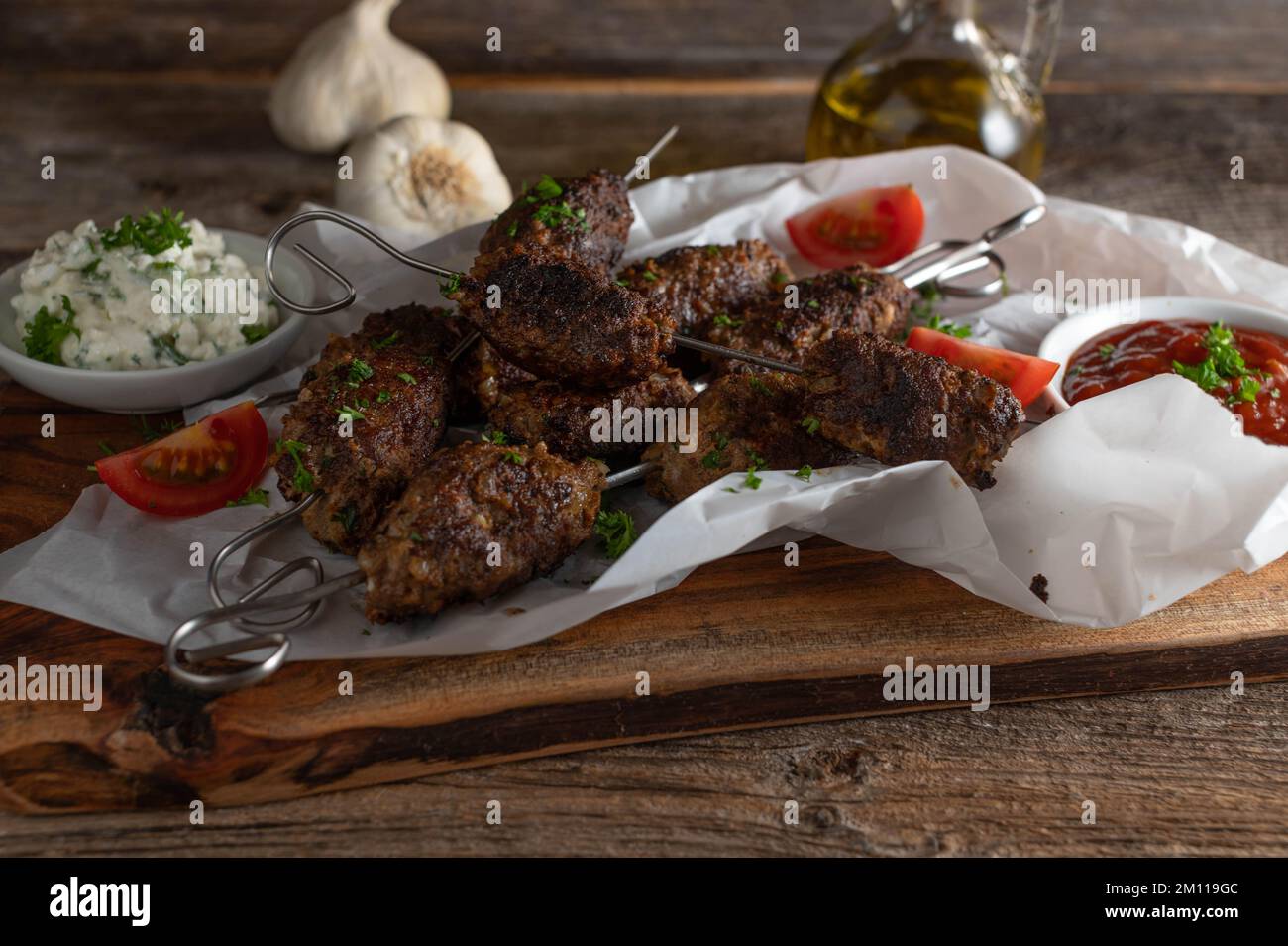 Mediterranean minced meat skewers with dipping sauce on rustic and wooden table Stock Photo