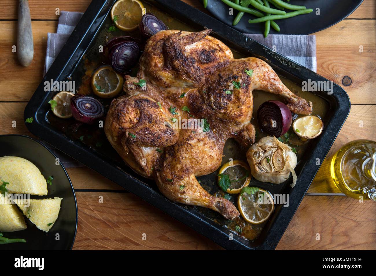 Roasted flat chicken with green beans and polenta, rumanian mamaliga Stock Photo