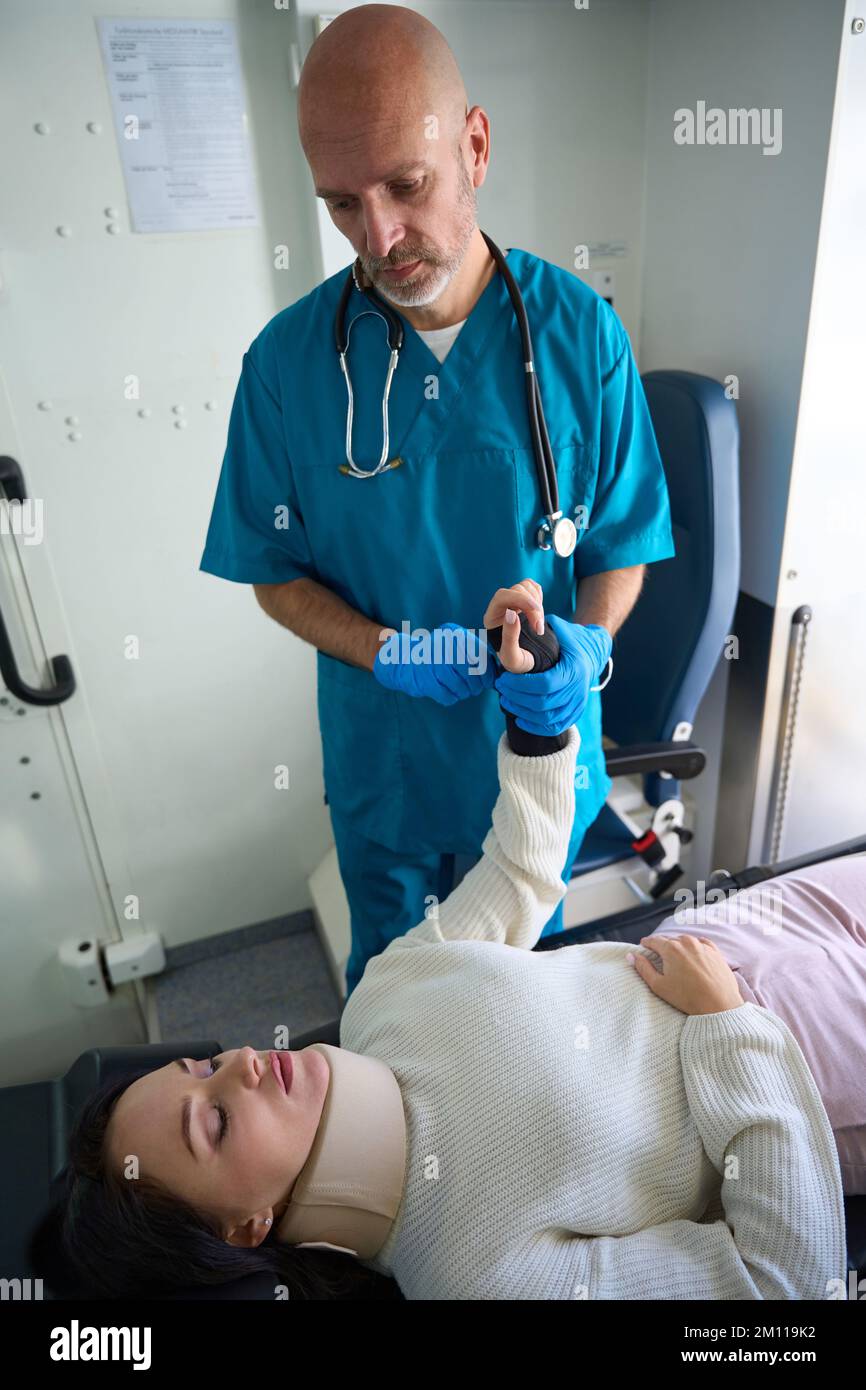 Woman with neck brace lies on gurney at medical procedure Stock Photo