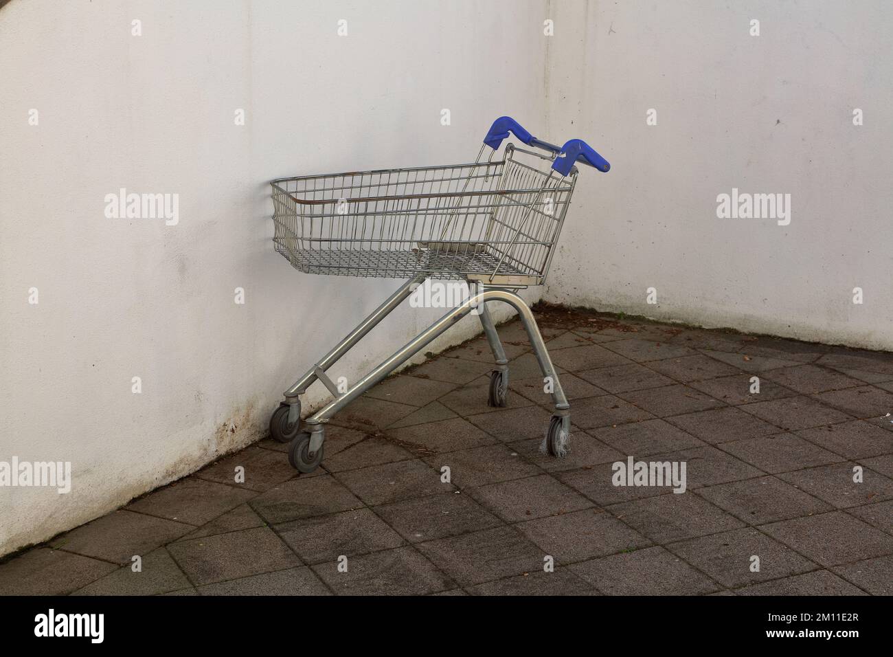 The good old shopping trolley from a local supermarket just abandoned in a corner some distance from the place of origin. Stock Photo