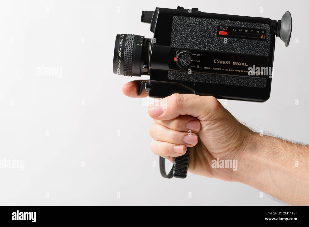 Izmir, Turkey - December 8, 2022: Hand holding a Canon 310xl Super 8mm amateur old fashion camera on a white background. Stock Photo