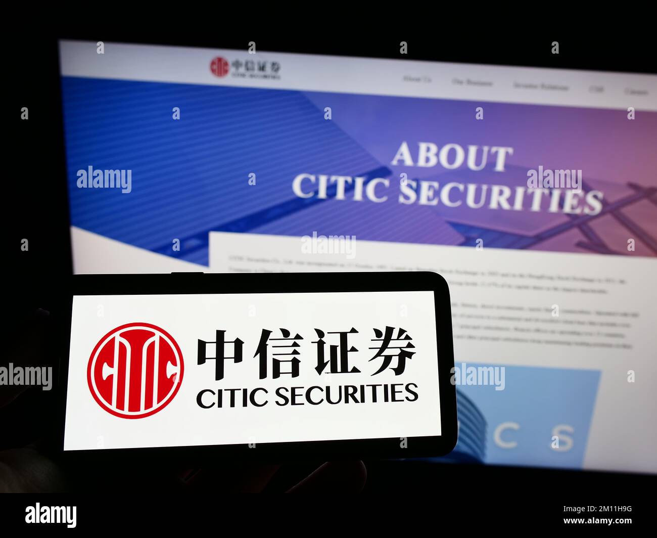 Person holding mobile phone with logo of Chinese company CITIC