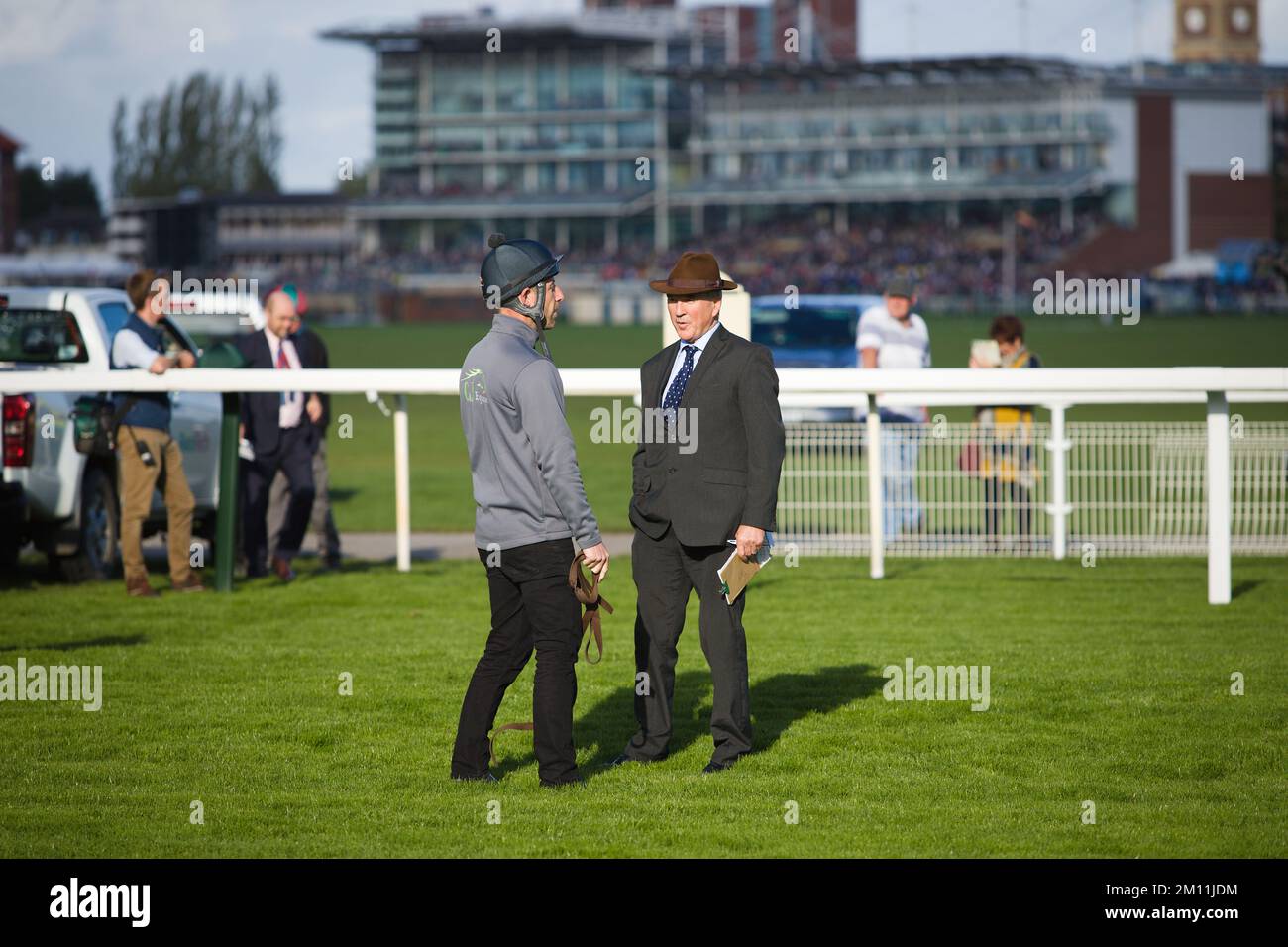 Racecourse staff chatting before the jockeys and their horses arrive at the starting gates at York Races. Stock Photo