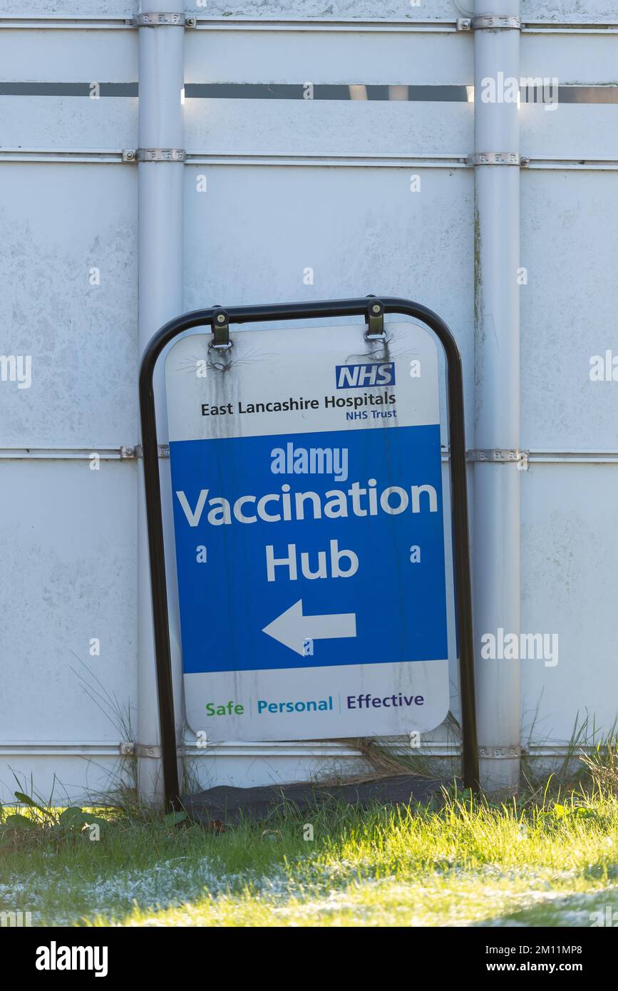 Taken at Royal Blackburn Teaching Hospital, Blackburn, Lancashire, UK on 9 December 2022. Old blue vaccination hub sign with white directional arrow. Stock Photo