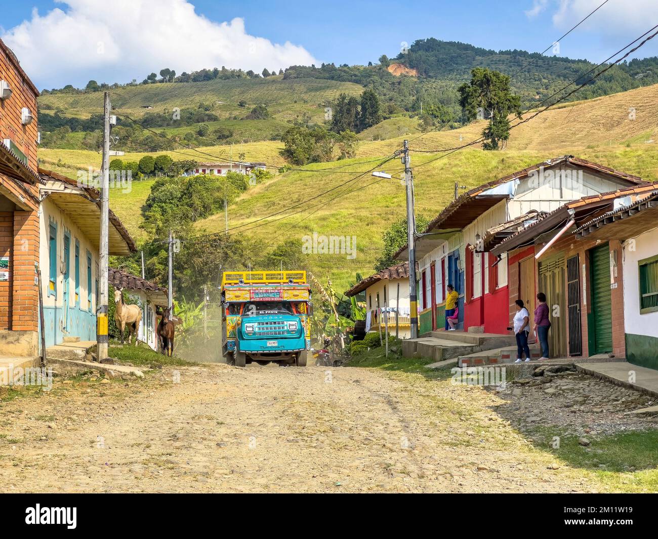 South America, Colombia, Departamento Antioquia, Colombian Andes, typical bus 'Chiva' on a dusty road in a small Andean village Stock Photo