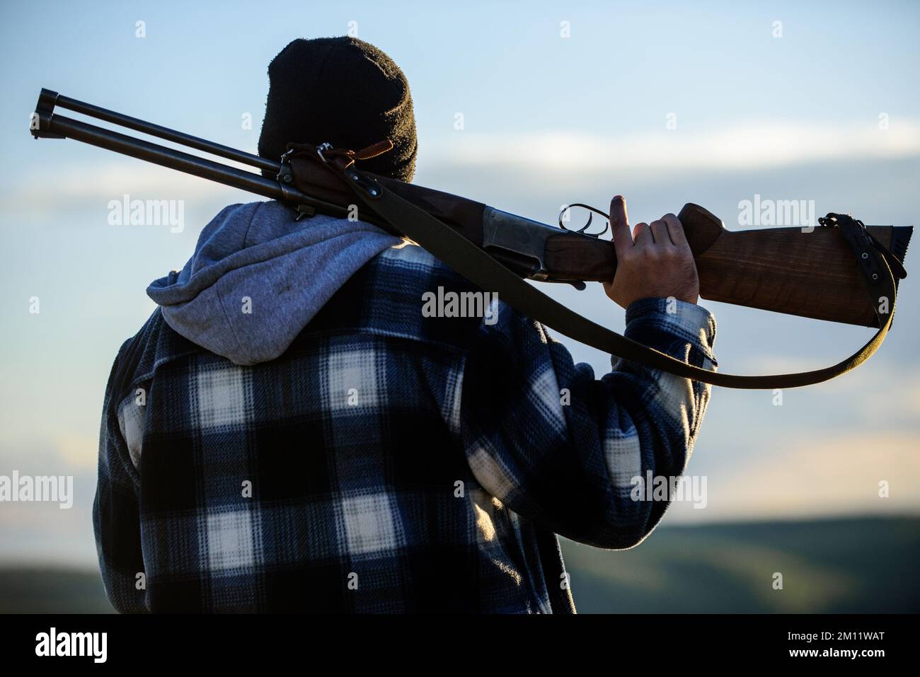 Hunter carry rifle gun on shoulder rear view. Guy hunter spend leisure ...