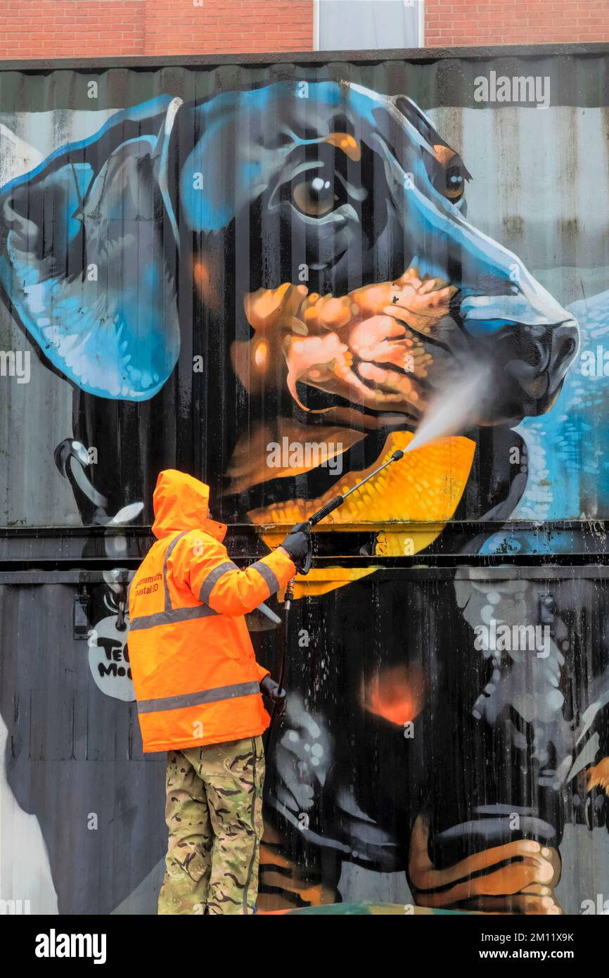 England, Dorset, Bournemouth, Boscombe, Council Worker Cleaning Street Art titled 'The Sausage Dog' by the Artist Tech Moon Stock Photo