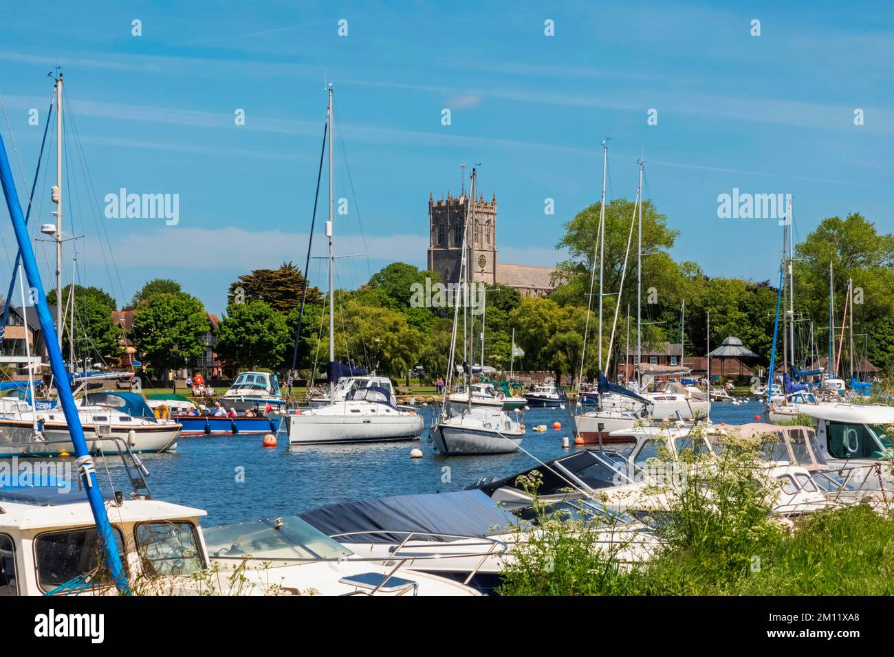 England, Dorset, Christchurch, Yachts on The River Stour and Christchurch Priory Stock Photo