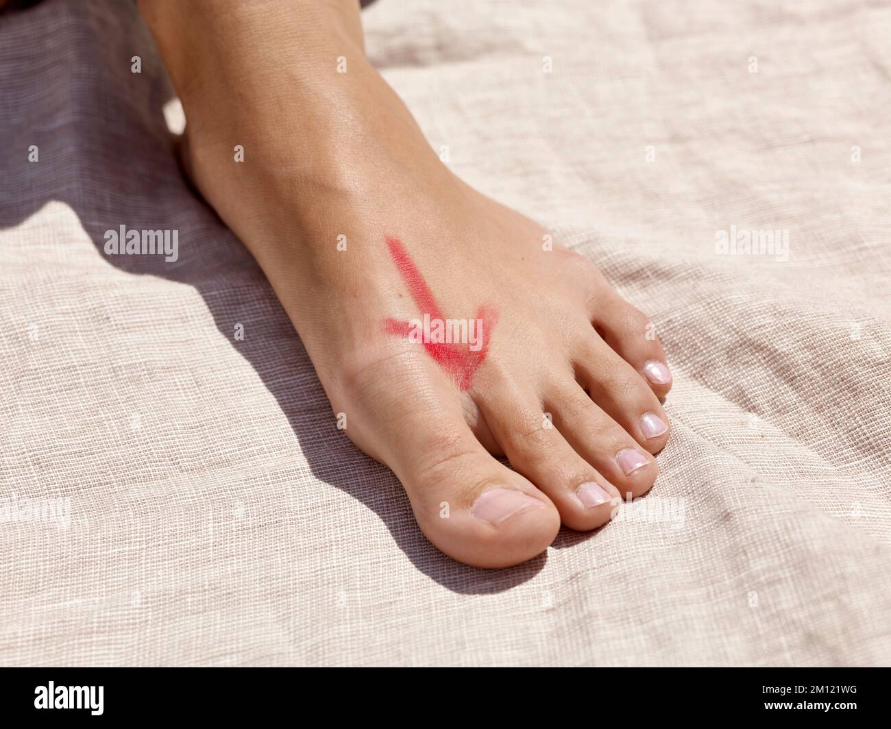 Barefoot walking - close-up of a woman's foot with reflexology zone drawn on the back of the foot in the shape of an arrow Stock Photo