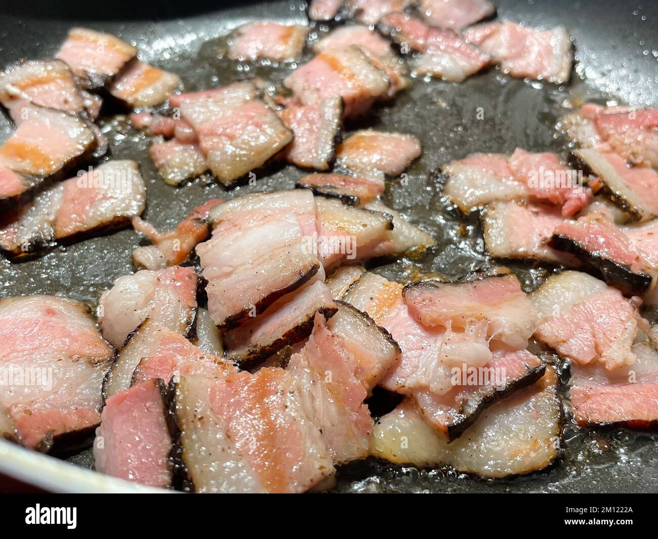 https://c8.alamy.com/comp/2M1222A/fried-fat-bacon-close-up-in-a-frying-pan-butter-with-bubbles-close-up-2M1222A.jpg
