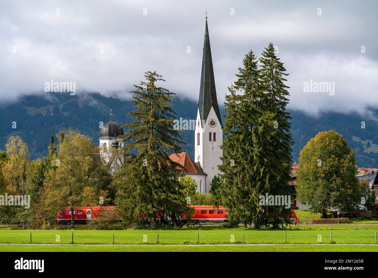 Regional train in front of the Lady Chapel and the Church of St. Verena in Fischen Stock Photo