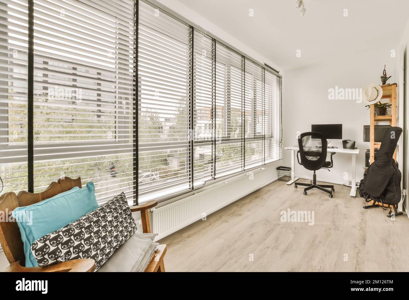 a living room with wood flooring and white shutters on the windows