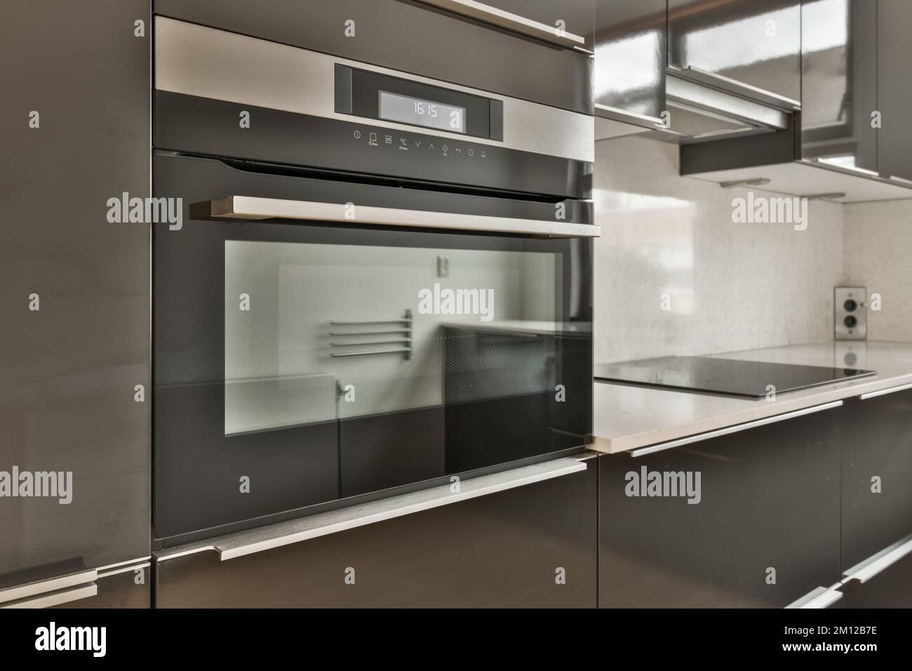 a modern kitchen with black cabinets and stainless steel appliances on the counter tops, in this case is an oven Stock Photo